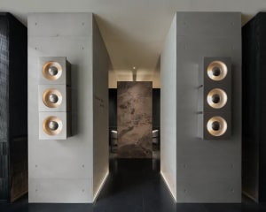 A modern living space with a stone wall and doorway, featuring bright lighting and a welcoming atmosphere