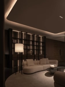 Cozy living room with white furniture, a bookshelf, and warm lighting