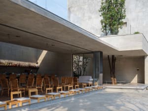 A modern patio with wooden chairs and dining tables arranged in a comfortable outdoor seating area, creating an inviting and relaxing atmosphere