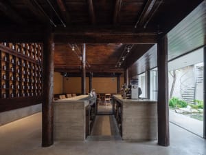 Warm and inviting restaurant with a wooden interior, featuring a bar area, dining tables, and natural lighting