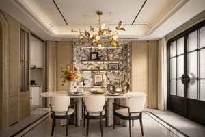 A modern dining room with a marble table, wooden chandelier, and comfortable seating, featuring a vase of flowers and soft warm lighting