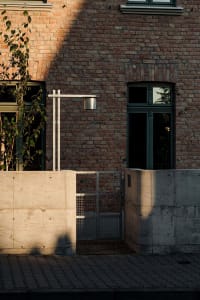A brick building with a metal railing in front, featuring a mix of materials and textures, with a sense of depth and perspective