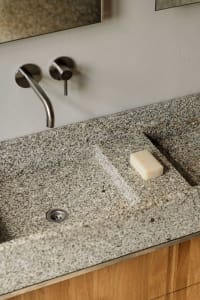 A well-maintained bathroom with a marble sink and a soap dish on the counter