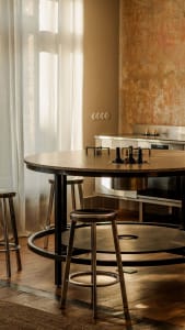 A residential kitchen with a dining table and chairs, black and white color scheme, and natural light creating a bright and clean atmosphere