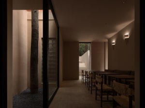 A well-lit restaurant with a modern design, featuring a dining area with tables and chairs, and a bar with a counter and stools