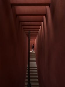Narrow hallway with a red brick wall, a staircase, and architectural details
