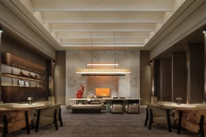 Cozy living space with a modern design, a large fireplace, and natural light from windows, featuring marble and wood materials