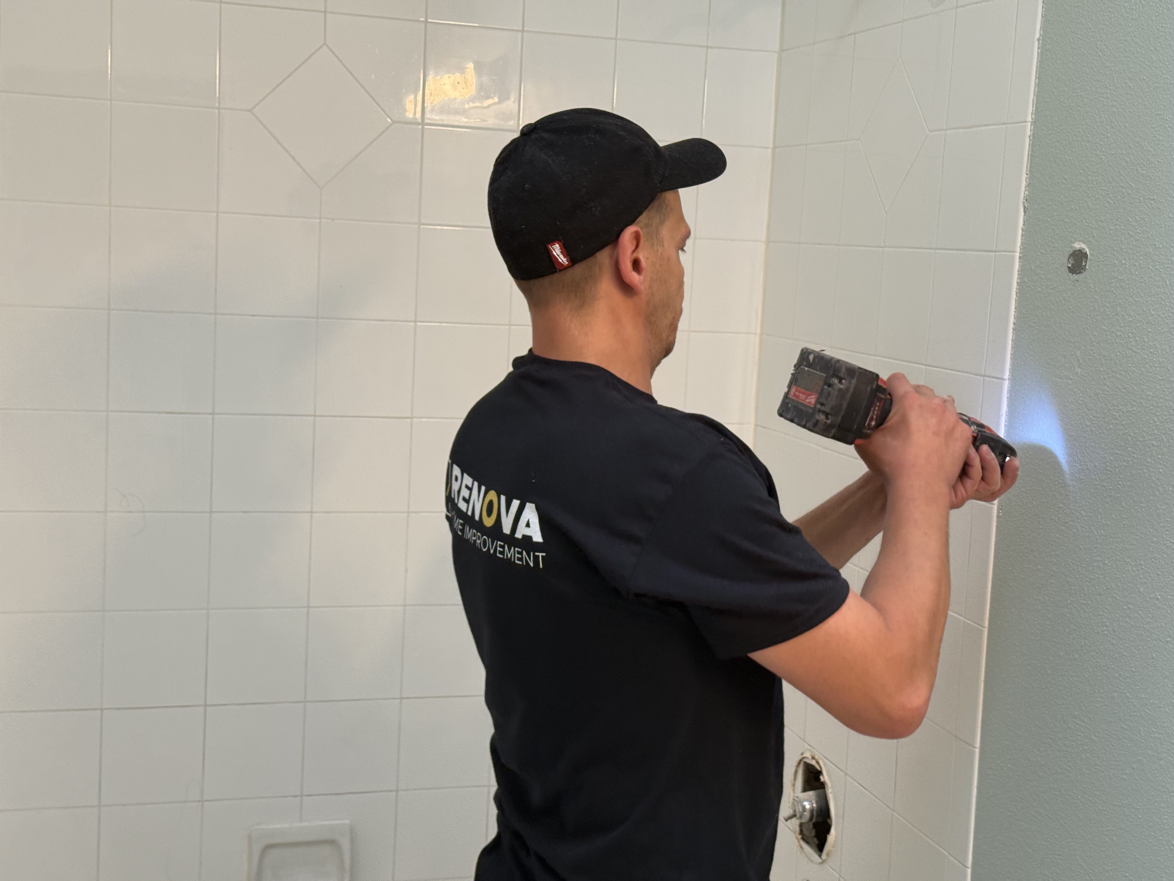 In progress: reciprocating saw at the shower wall, fixtures coming off cleanly