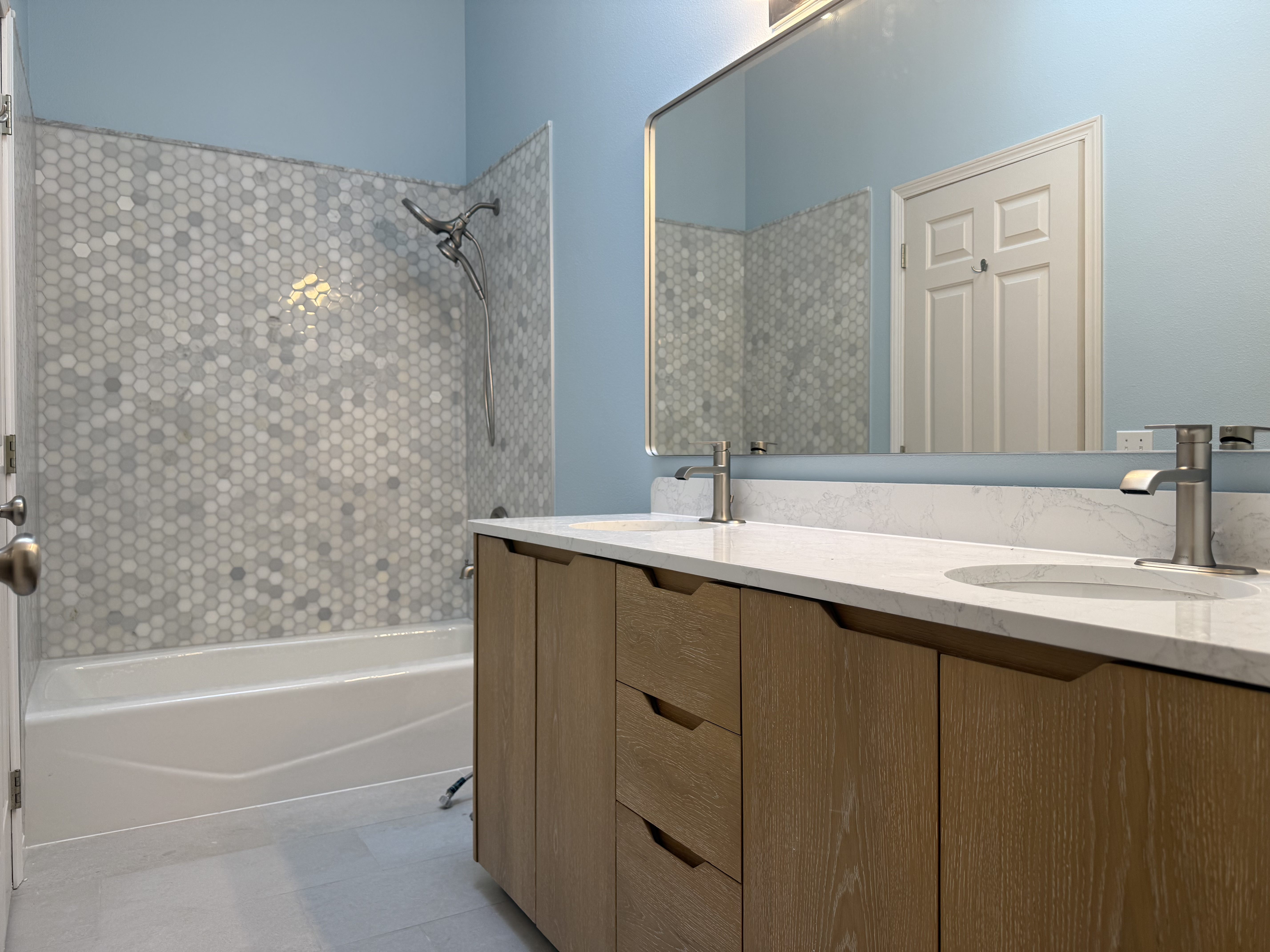 Demo: walls open to studs with insulation exposed; vanity wall re-piped; light bar temporarily left for work light