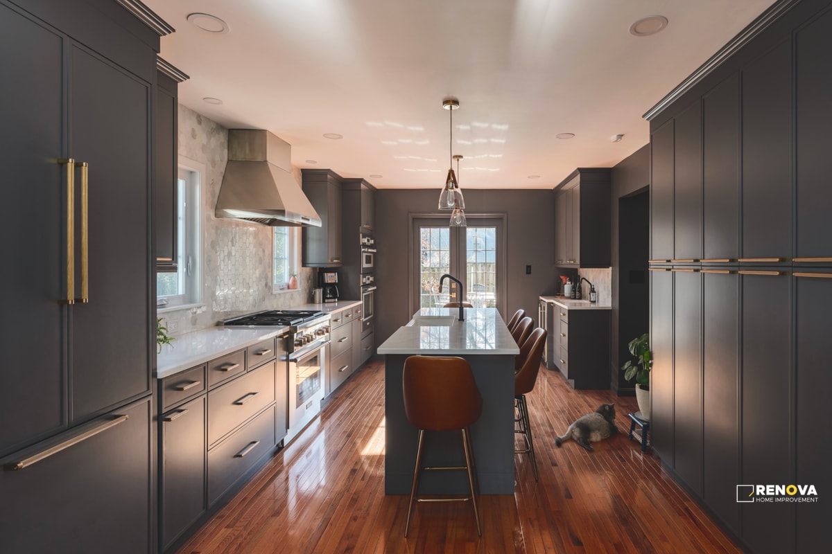 Complete kitchen remodeling Bellevue with dark gray cabinets, center island with seating, stainless steel appliances, and wood flooring - modern kitchen renovation services.