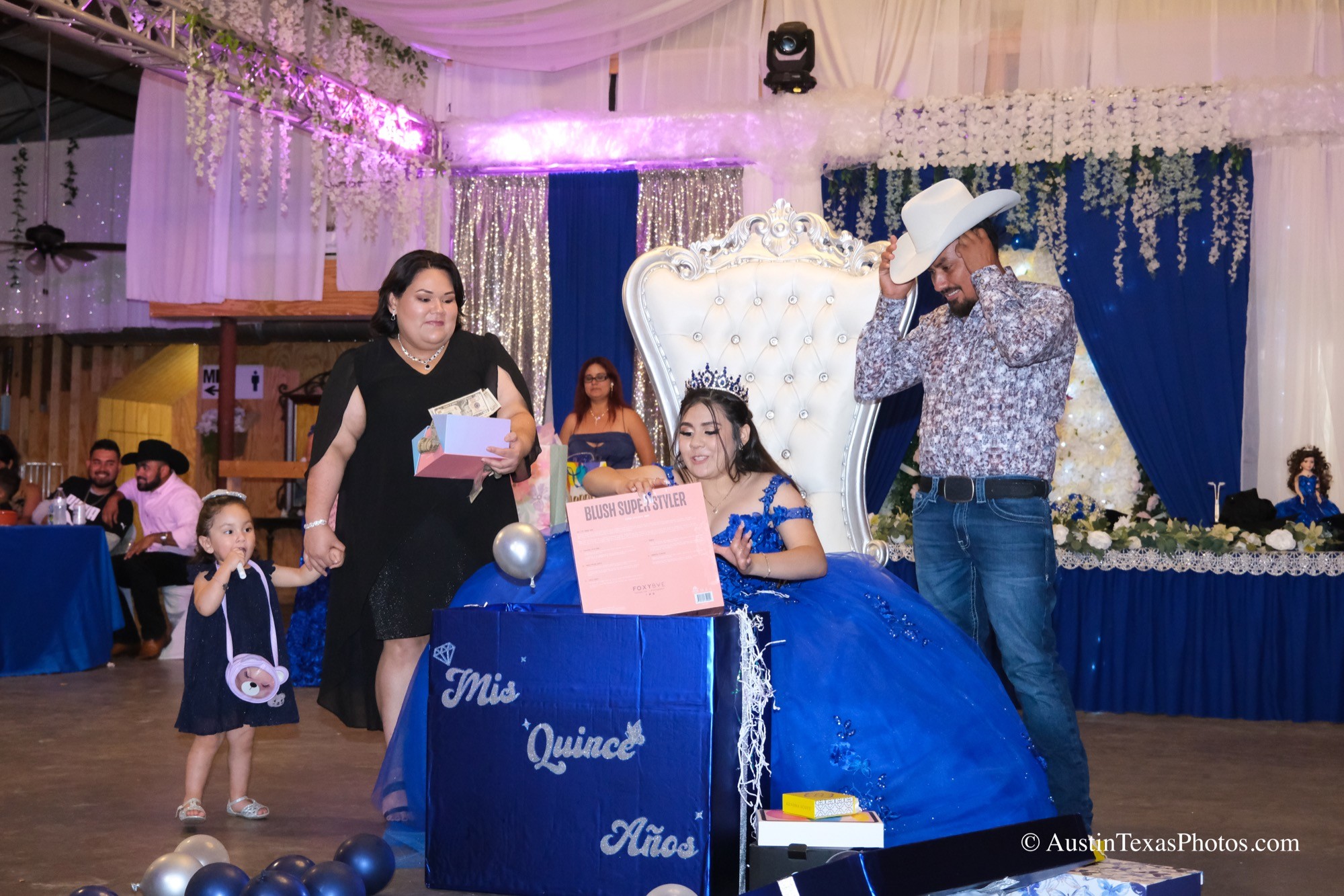 Quinceañera opening surprise gifts with her aunts and uncles at reception