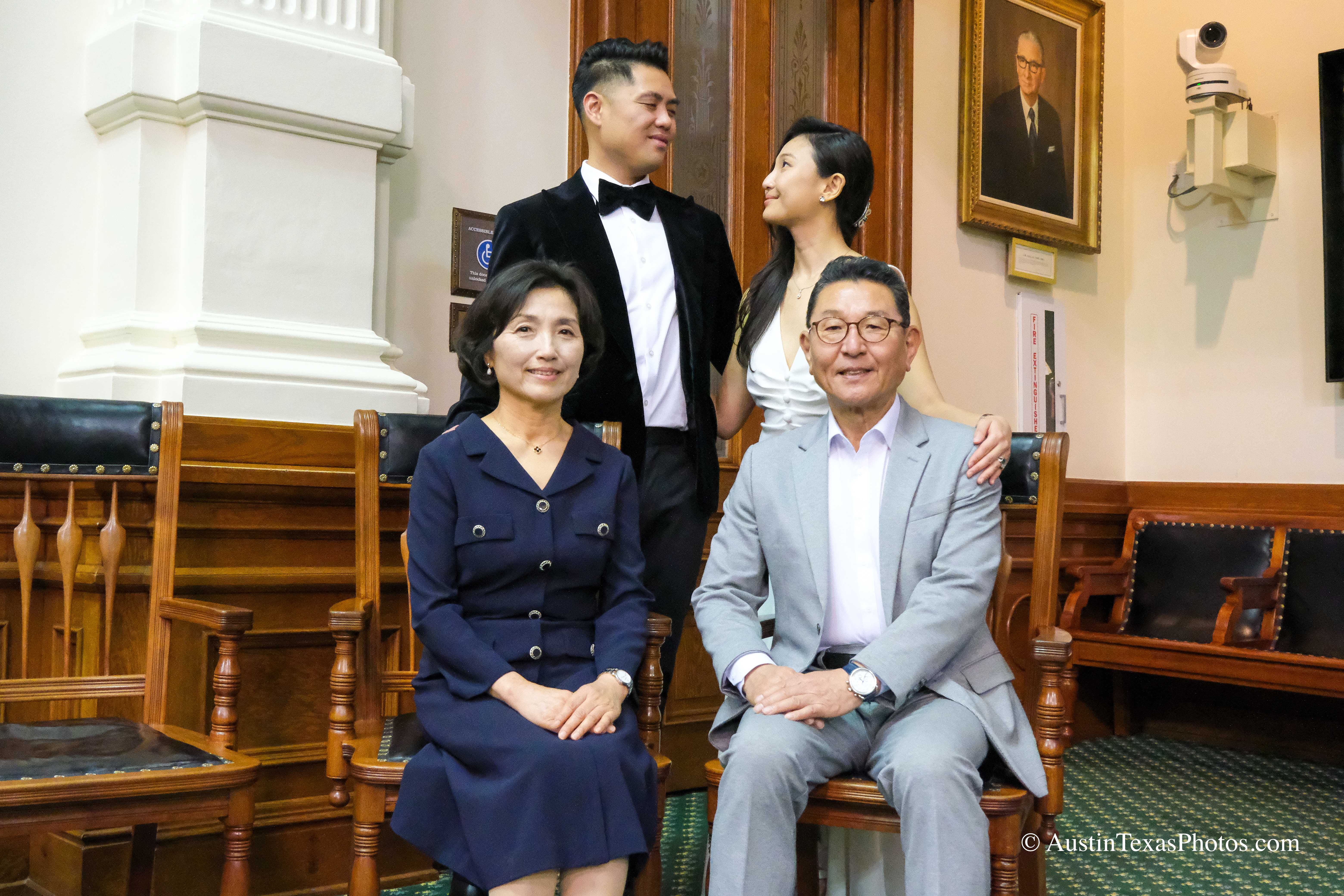 Bride and groom with seated parents inside the Texas State Capitol, Austin, Texas