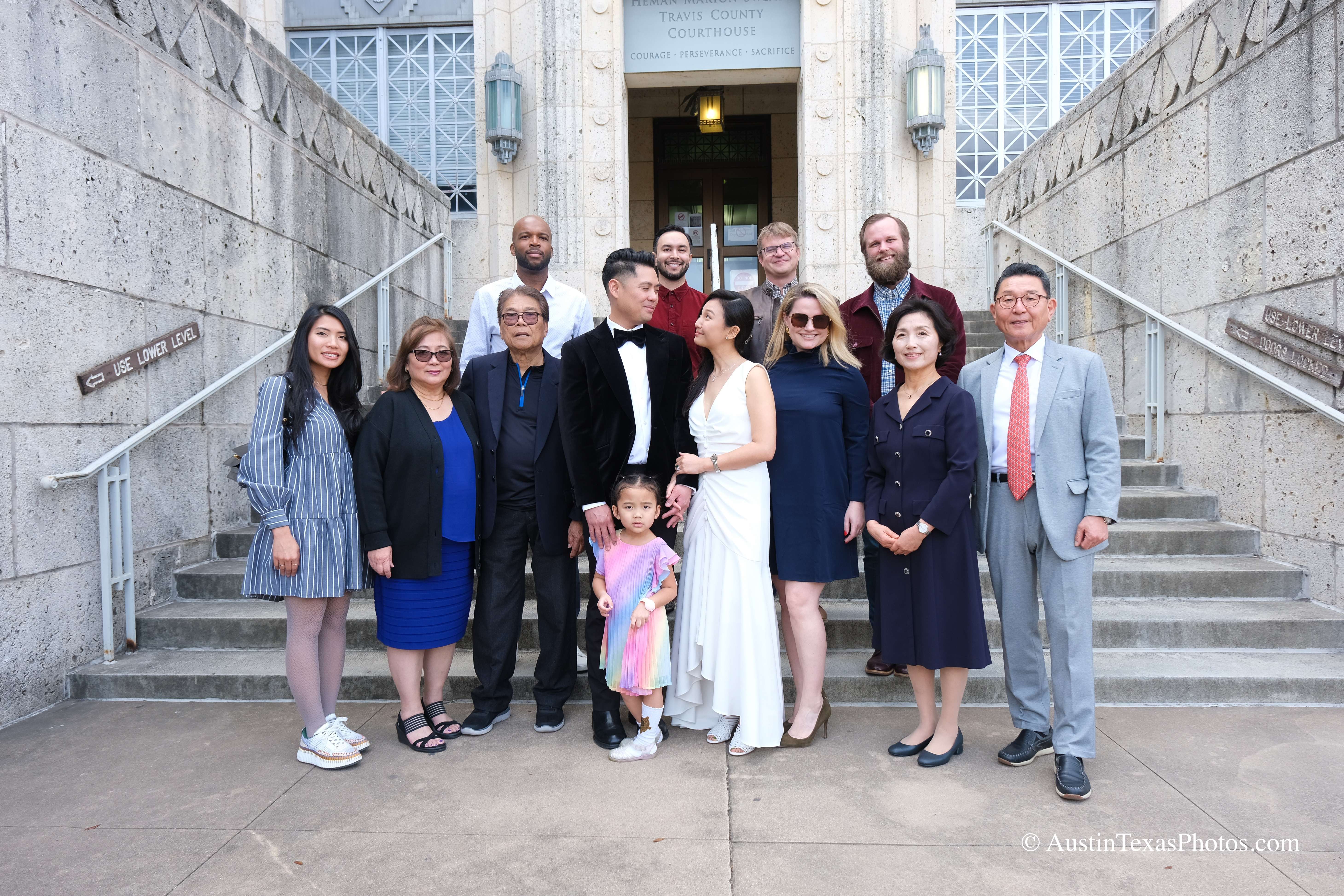 Full wedding family group portrait outside the downtown Austin courthouse