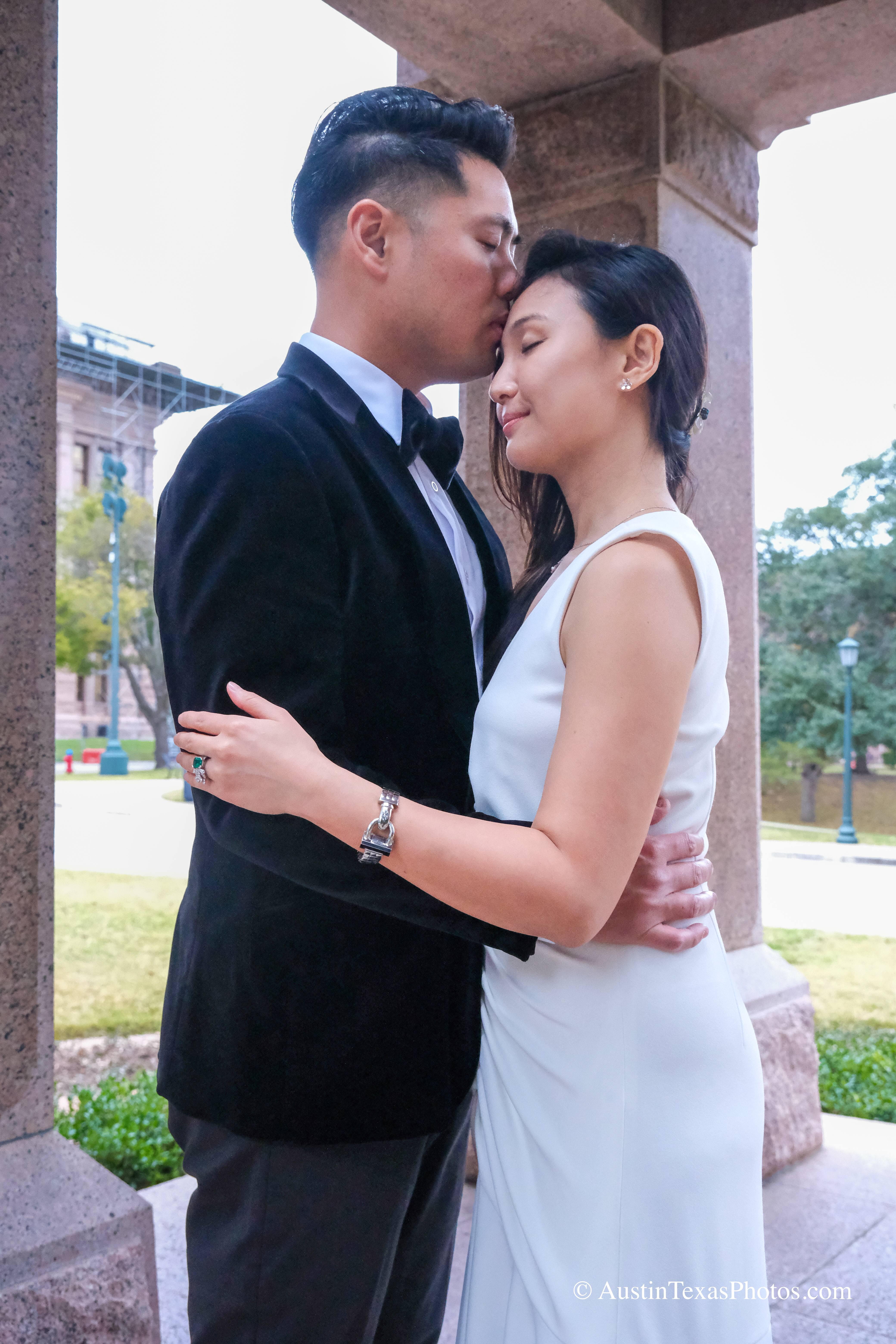 Groom kissing bride on the forehead at the Texas State Capitol, Austin, Texas
