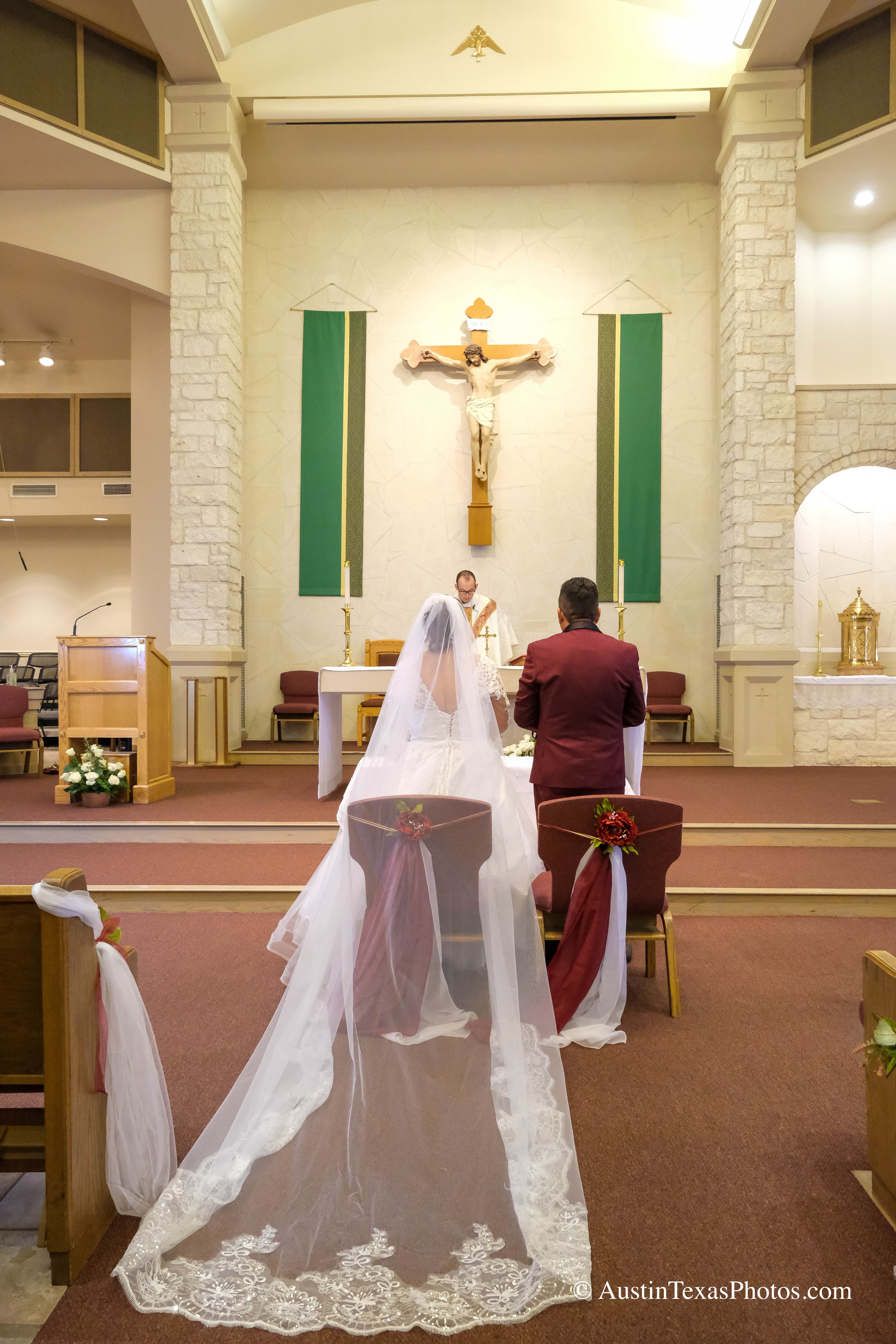 Bride in wedding gown at the altar showing dress train at Santa Cruz Catholic Church