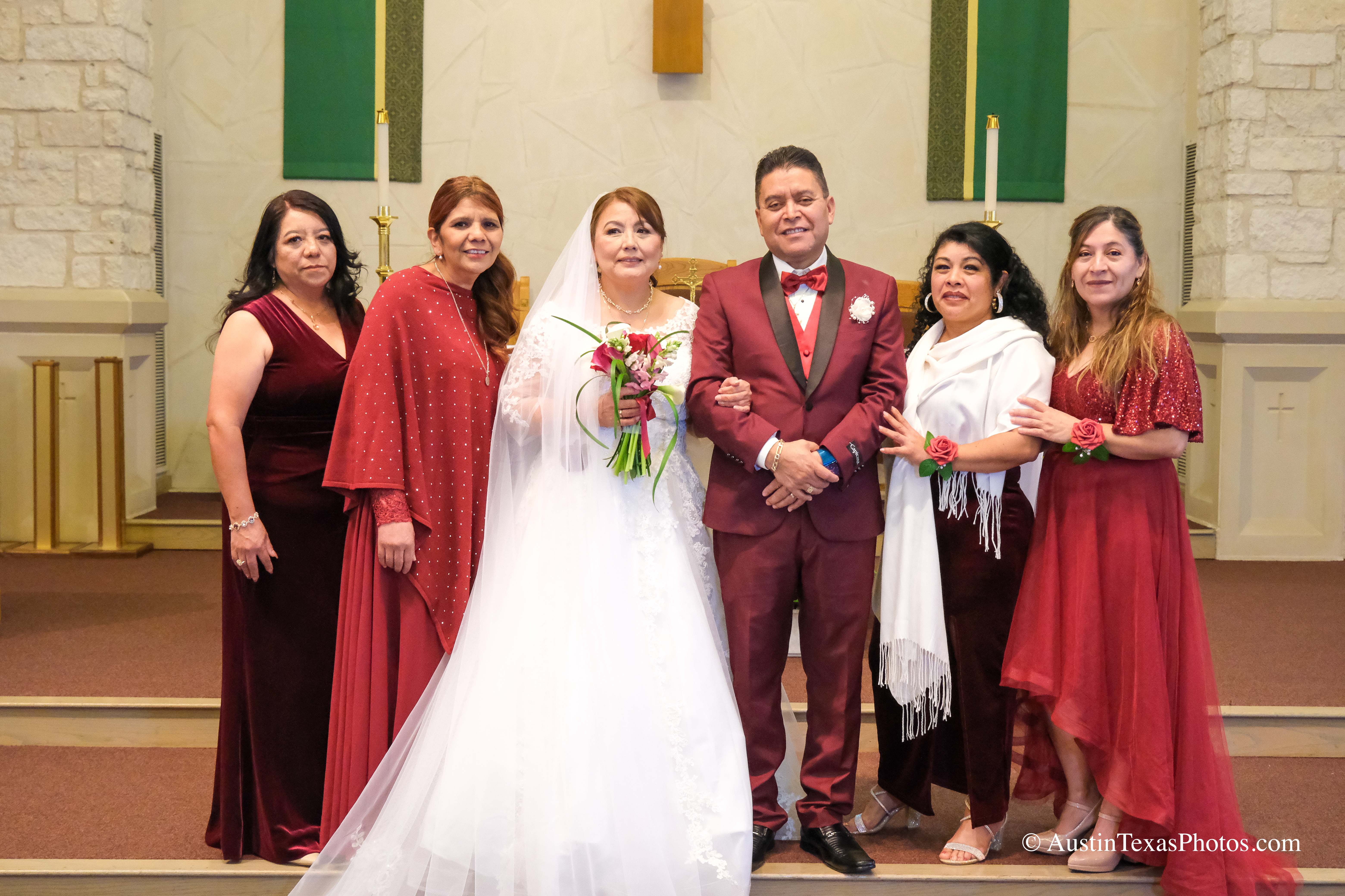 Wedding family portrait at the altar with bride and groom