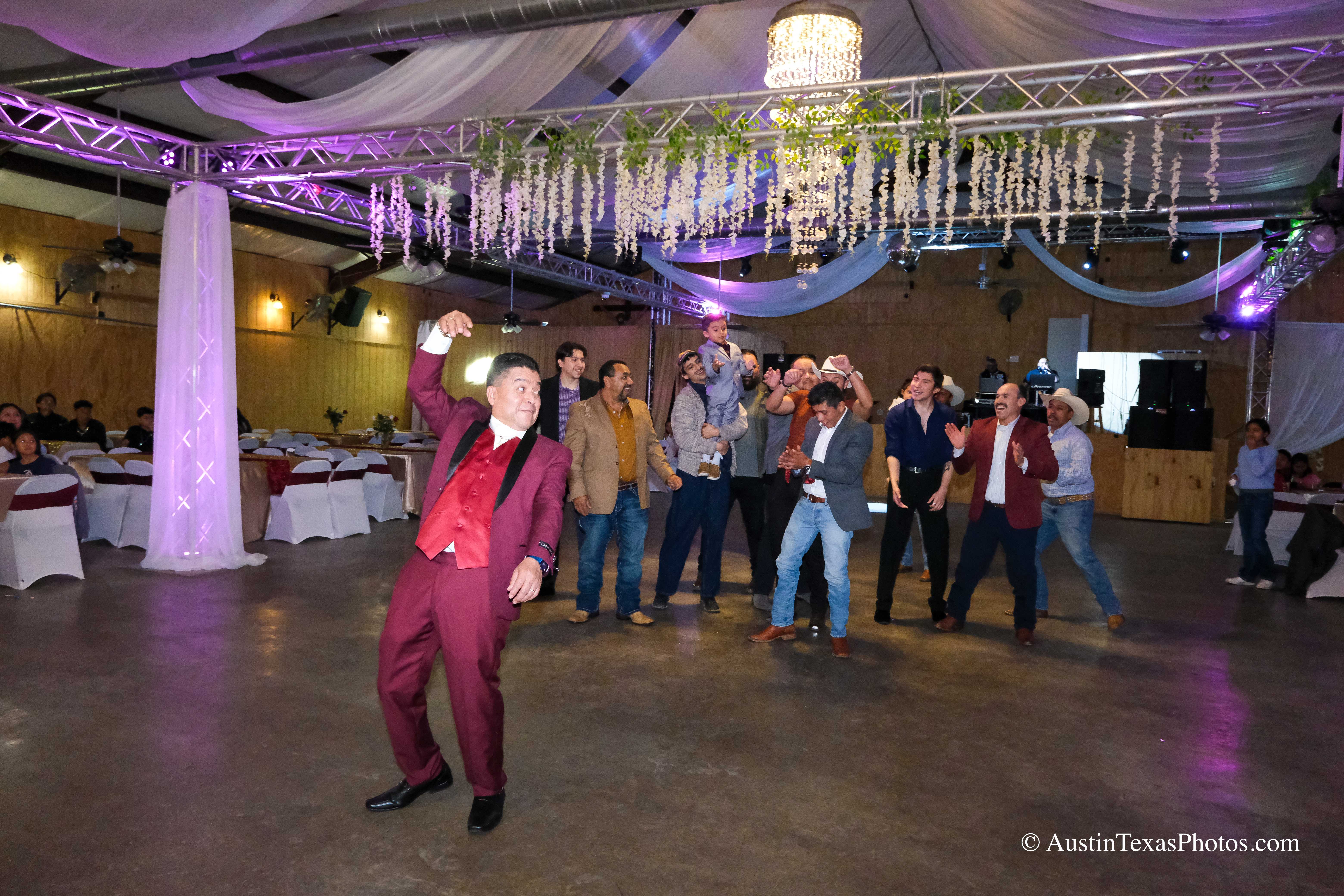 Groom tossing garter to single men at wedding reception