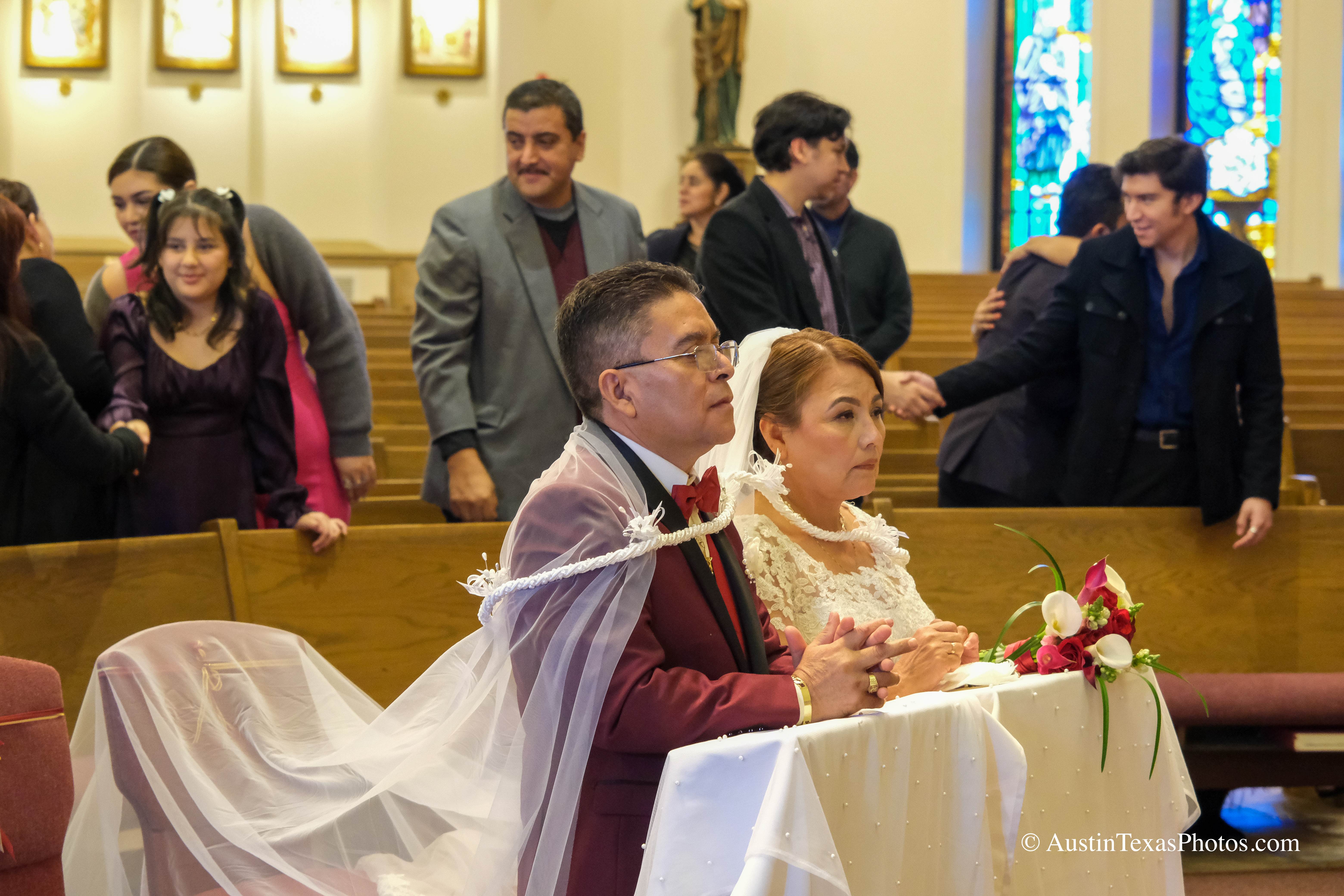 Bride and groom kneeling at the altar during wedding mass