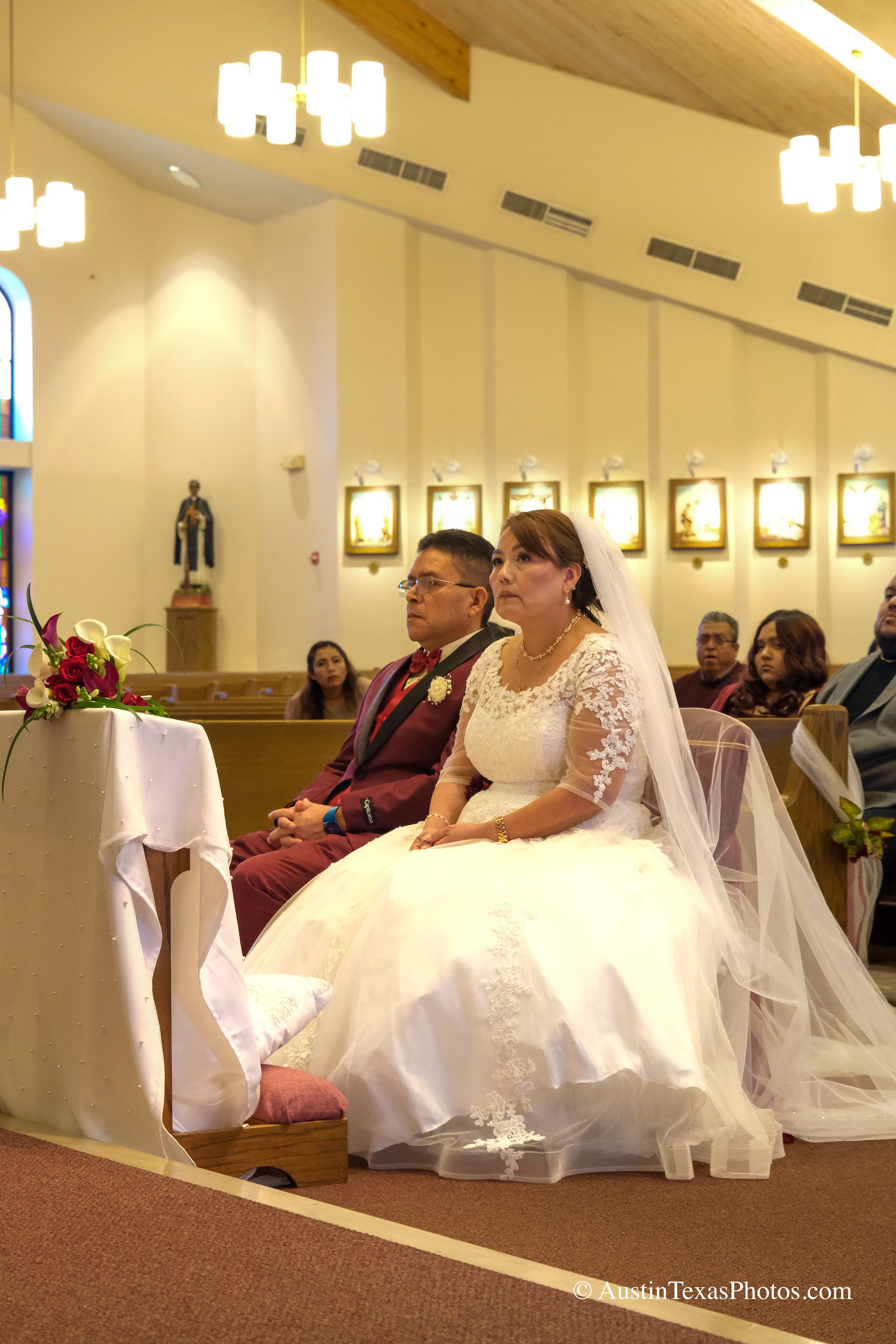 Bride and groom seated close together at the altar during wedding ceremony