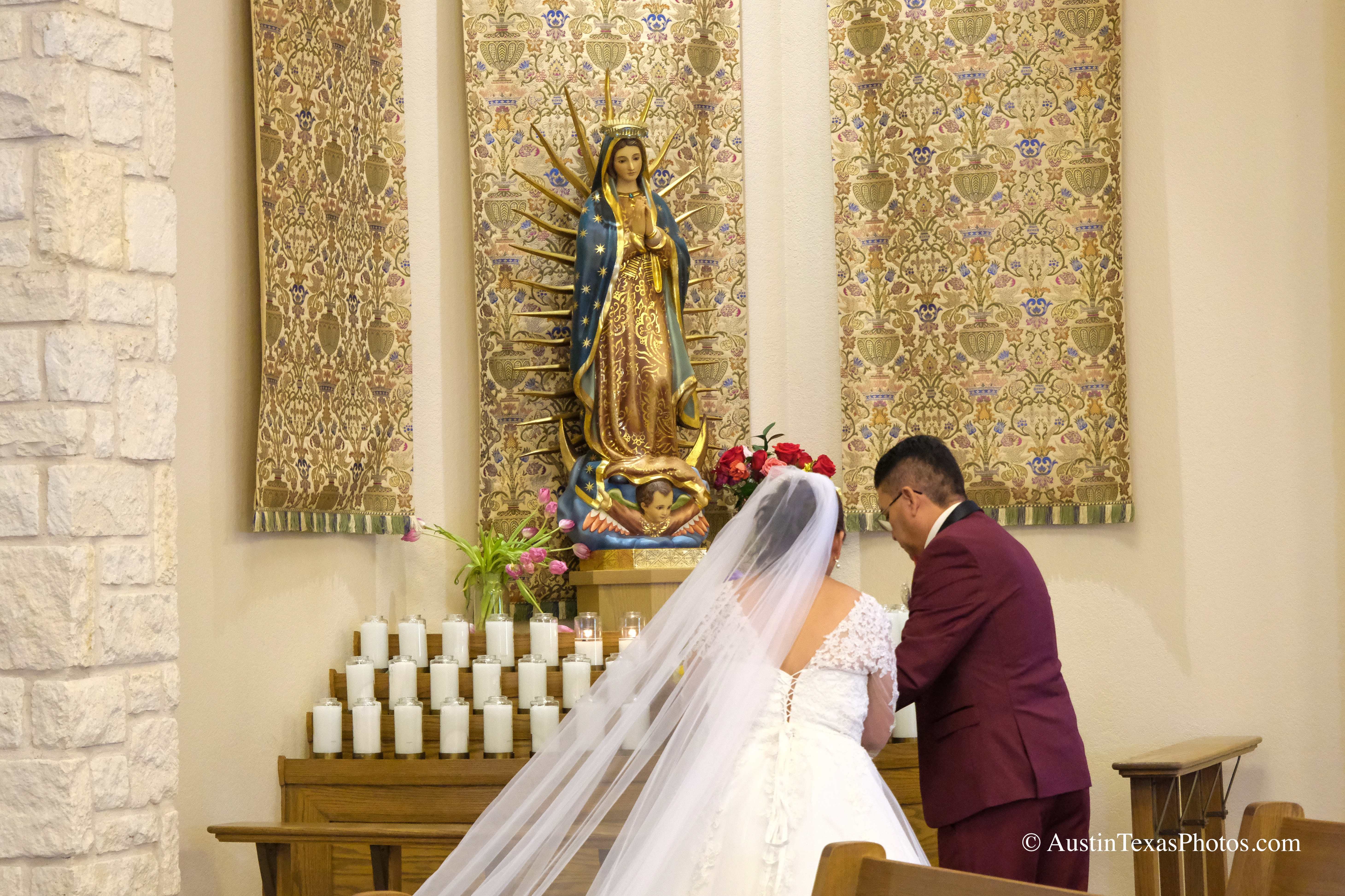 Bride and groom posing in front of Virgin Mary shrine at Santa Cruz Catholic Church