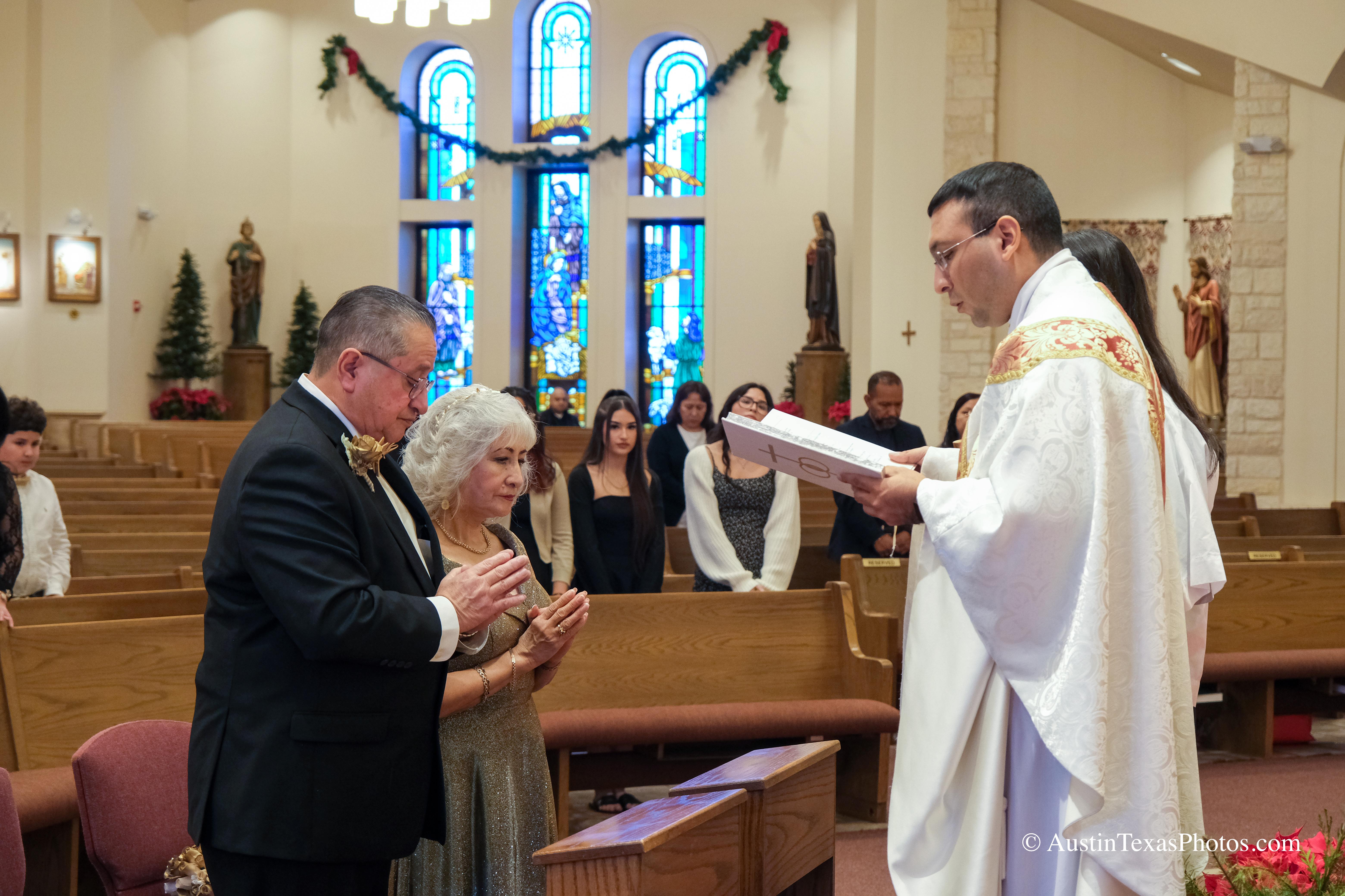 Bride and groom kneeling at the altar during Catholic wedding mass
