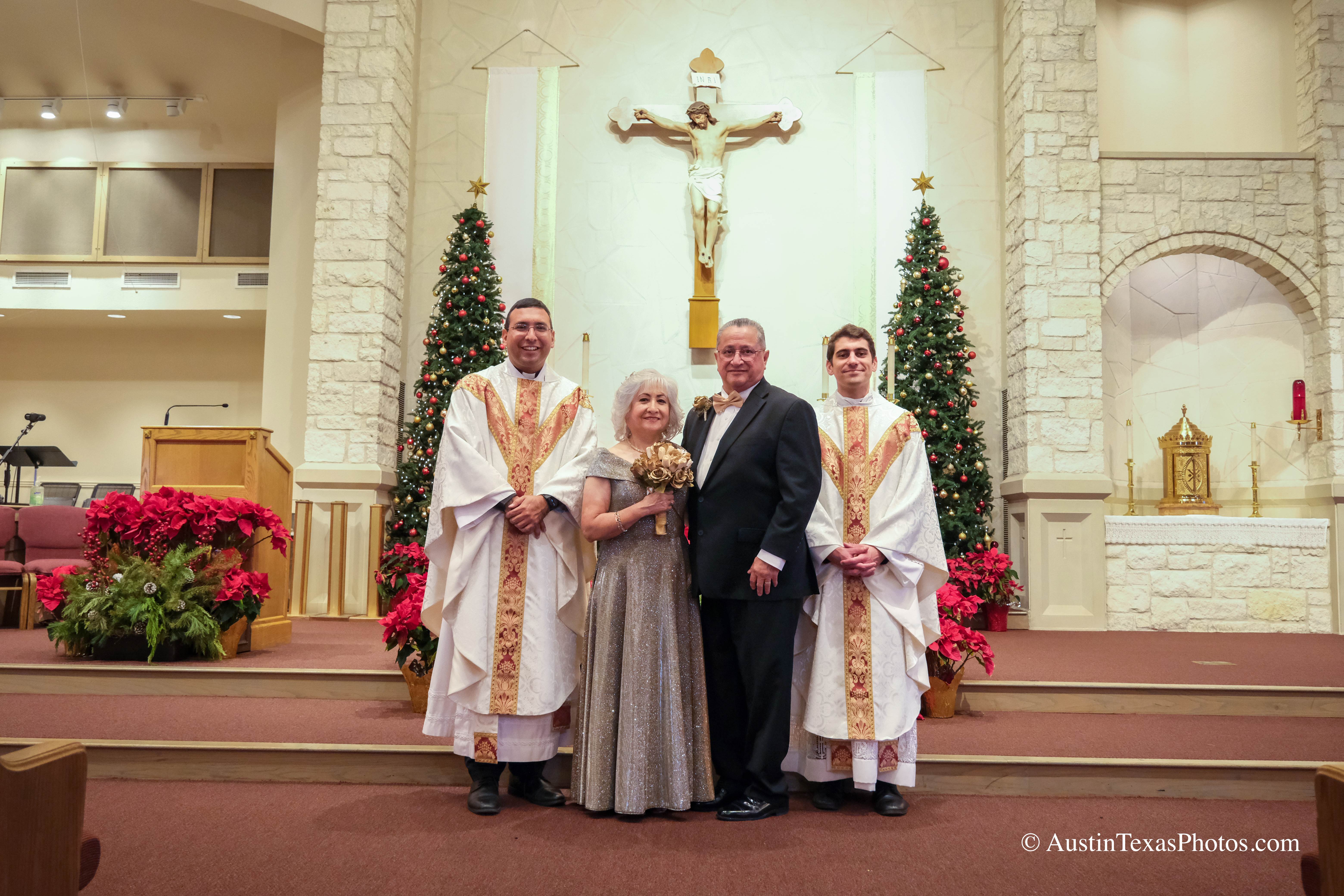 Bride and groom posing with priest at the altar after wedding ceremony