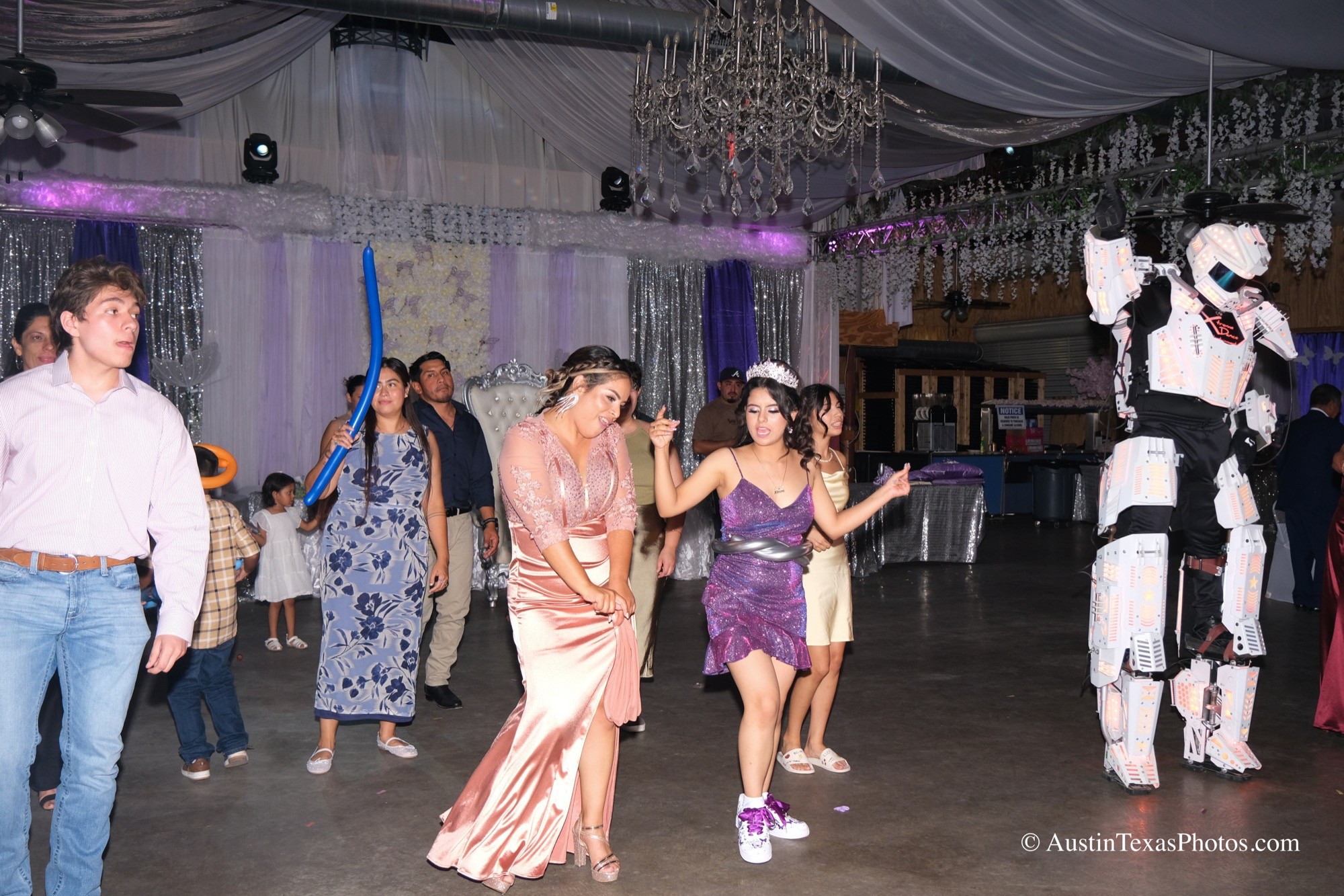 Mother and daughter dancing with a robot and guests in the background