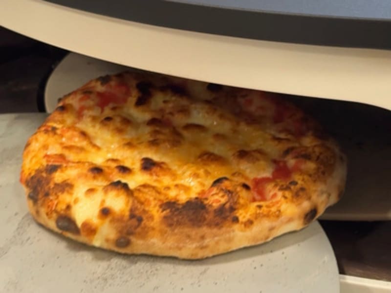 Pizza neapolitańska wyjmowana z rozgrzanego pieca