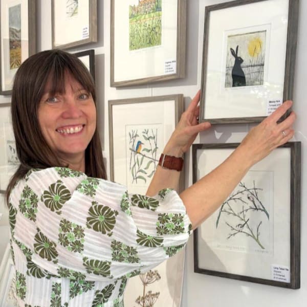 Alison Hullyer in her studio arranging pictures on the wall