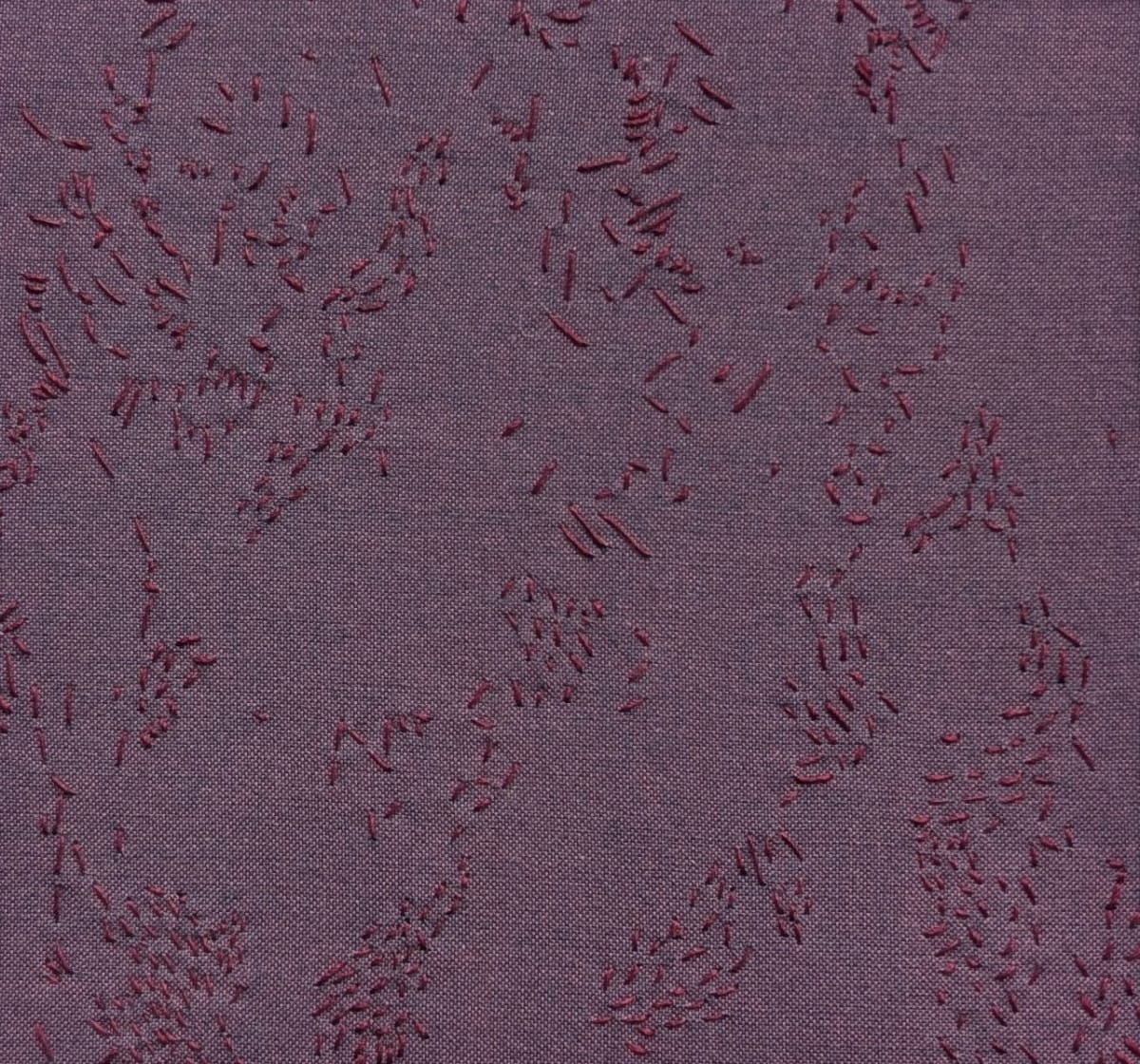Purple fabric with burgundy stitching creating flowing abstract forms.