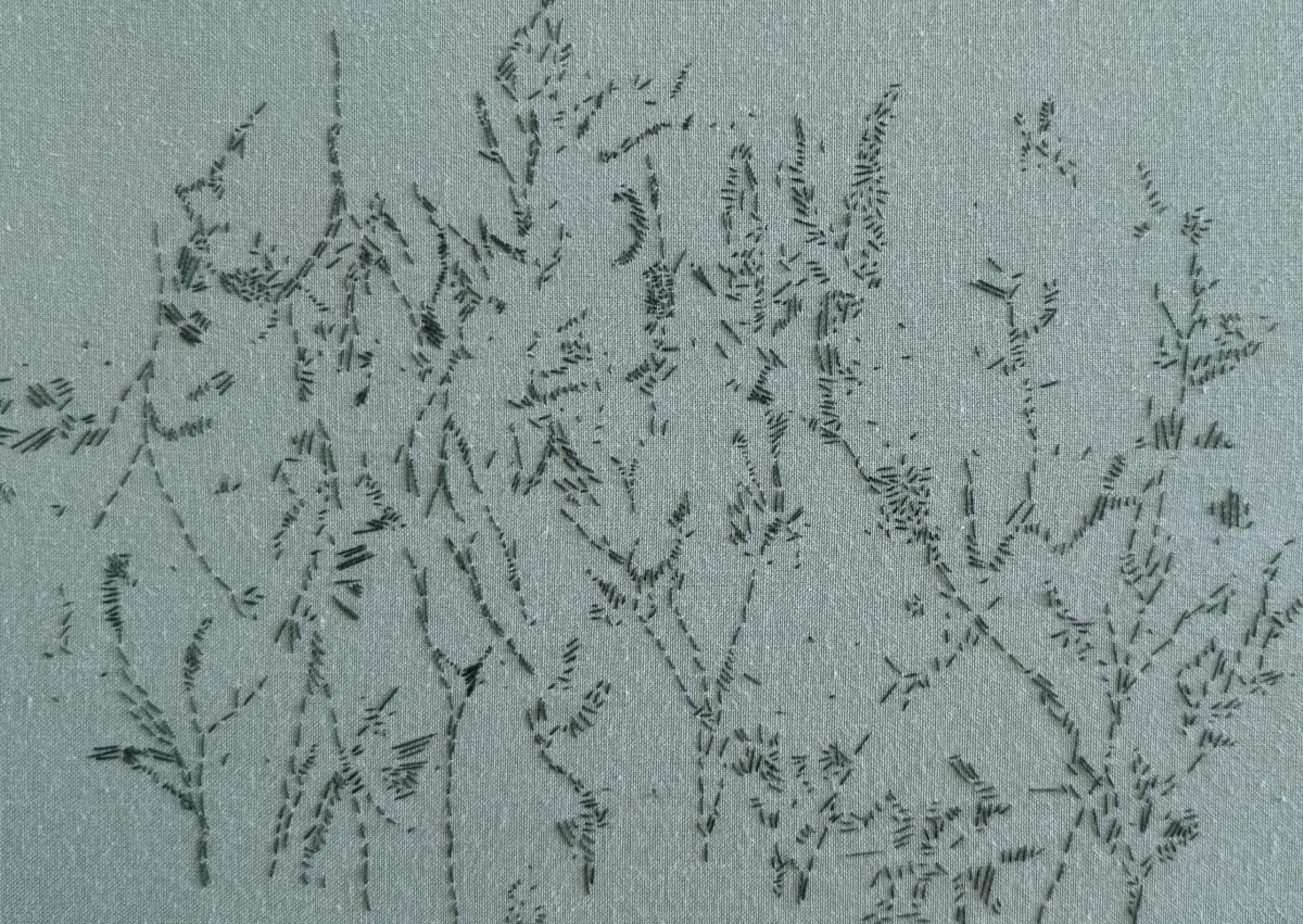Green fabric, with delicate dark green embroidery creating abstract images of willow trees and reeds.