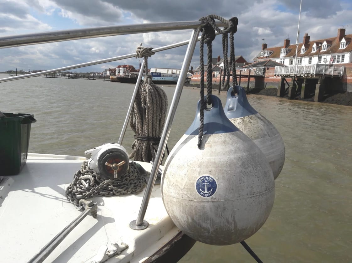 Burnham-on-Crouch quay with mooring buoys, ropes and the white-painted Royal Corinthian Yacht Club in the background