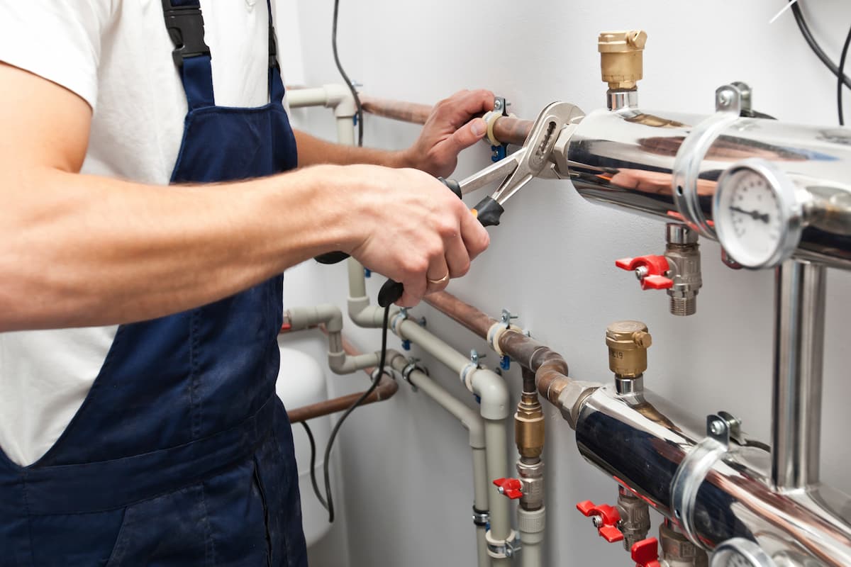 A burst water pipe causing significant water damage indoors, showing the urgency of emergency plumbing response