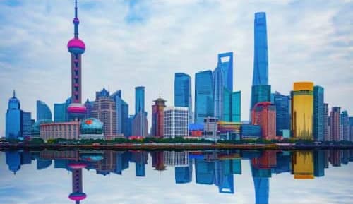 Shanghai skyline with Oriental Pearl Tower and modern skyscrapers reflected in calm water