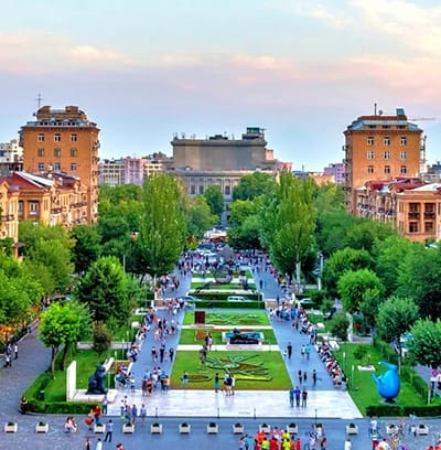 Aerial view of Republic Square in Yerevan with fountains, green spaces, and surrounding Soviet-era buildings at dusk