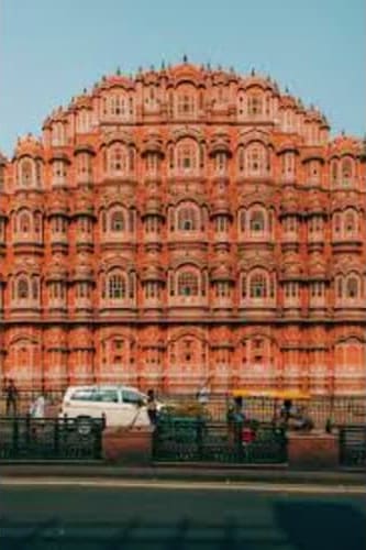 Hawa Mahal palace facade in Jaipur with pink sandstone architecture and ornate windows against blue sky