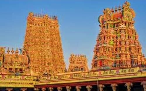 Ancient Hindu temple with ornate golden gopurams and colorful sculptures in Madurai, India