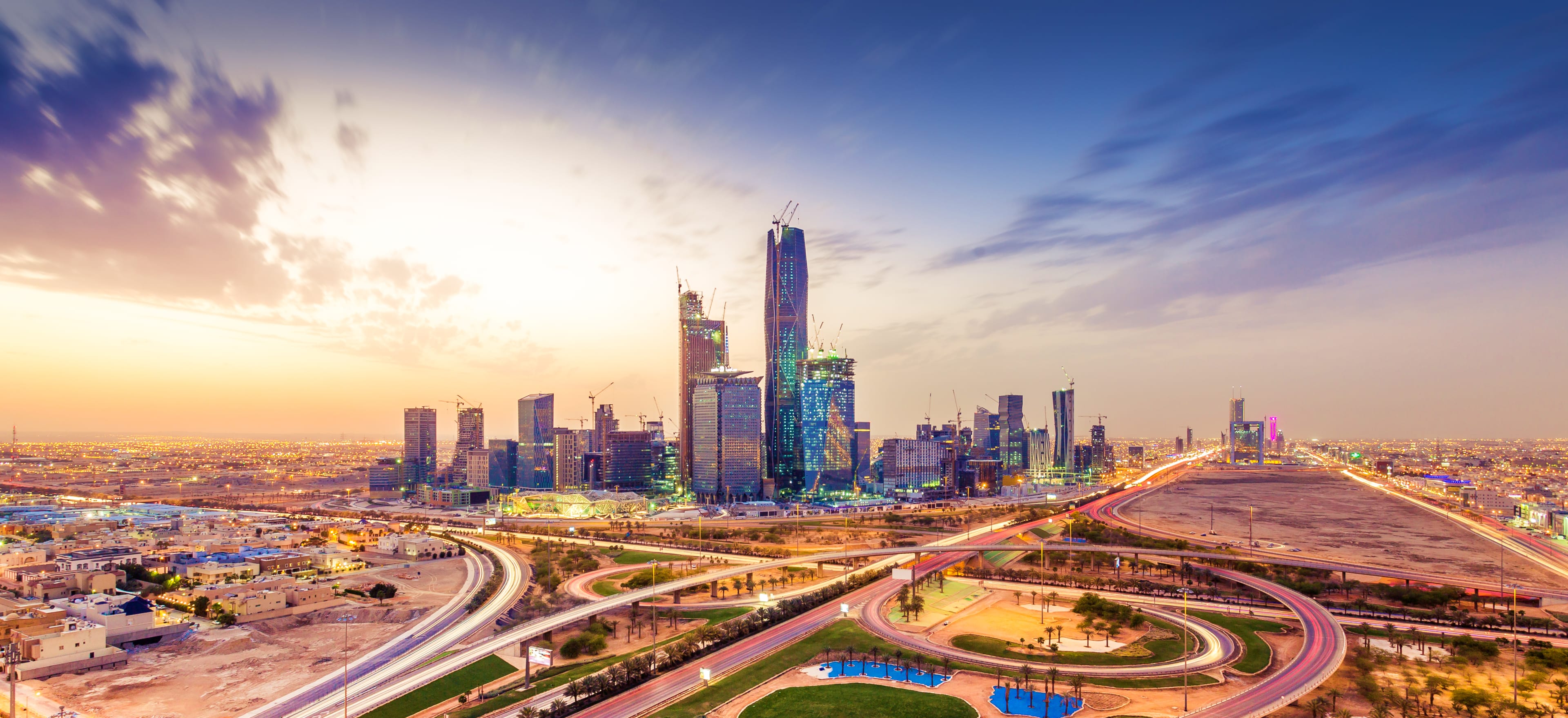 Riyadh skyline at sunset with illuminated highways, modern skyscrapers, and downtown cityscape at dusk
