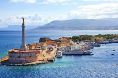 Messina harbor with Madonnina lighthouse, historic fortifications, and cruise ships docked in Mediterranean waters with mount