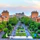 Aerial view of Republic Square in Yerevan with fountains, green spaces, and surrounding Soviet-era buildings at dusk