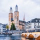 Gross Münster church with twin spires and Münsterbrücke stone bridge over Limmat River in Zurich's historic Old Town