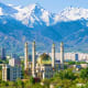Islamic mosque with golden dome in Almaty city center with snow-capped mountains in background