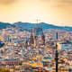 Barcelona cityscape with Sagrada Familia cathedral and surrounding buildings under golden sunset light