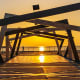 Sunset view through modern black metal structure at Dammam waterfront with water tower and palm trees in background