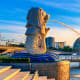 Merlion statue in Marina Bay Singapore with water fountain, modern buildings and blue sky