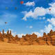 Hot air balloons floating over rocky desert landscape and sandstone formations in Al Ula, Saudi Arabia
