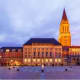 Historic Kiel city square at dusk with illuminated town hall and church spire, Germany