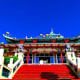 Traditional Chinese temple with ornate curved roof and gold dragons against blue sky in Cebu City, Philippines