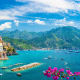 Atrani village on Amalfi Coast with colorful buildings, turquoise Mediterranean Sea, green mountains, and pink bougainvillea 