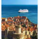 Cruise ship anchored off the coast of Dubrovnik's walled Old Town with terracotta roofs and historic fortifications